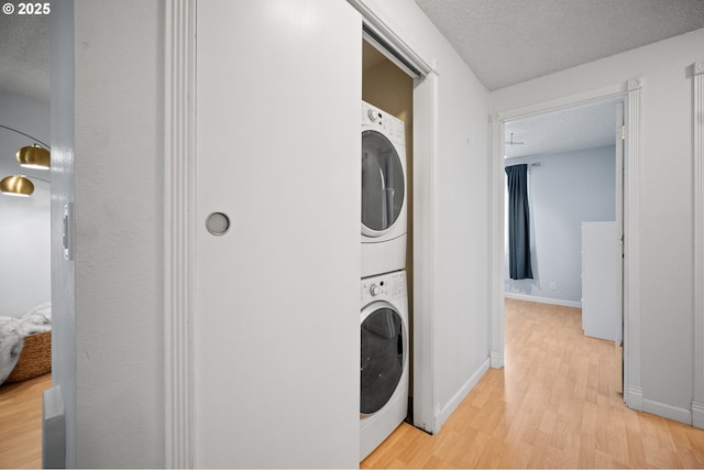 621 SE 121st Ave Unit 29, Vancouver, WA 98683 - laundry area with stacked washer / drying machine, light wood-type flooring, and a textured ceiling