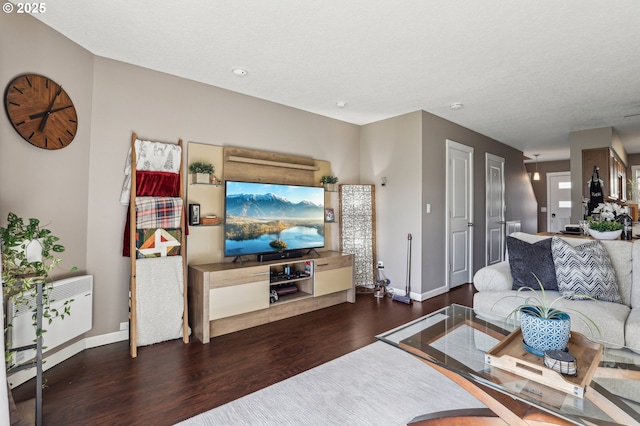 living room featuring dark hardwood / wood-style floors and a textured ceiling