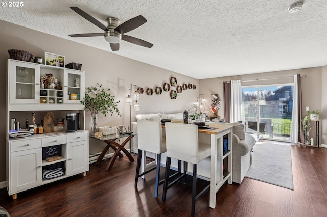 dining space with a textured ceiling, dark hardwood / wood-style flooring, and baseboard heating