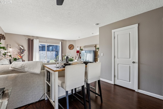 dining room featuring a textured ceiling and dark hardwood / wood-style flooring