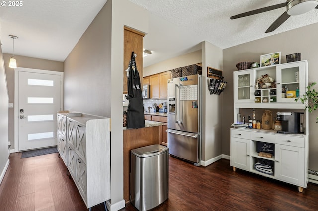 kitchen with dark wood-type flooring, white cabinetry, hanging light fixtures, a textured ceiling, and stainless steel appliances