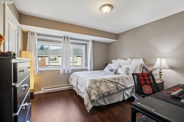 bedroom with baseboard heating, dark wood-type flooring, and a textured ceiling