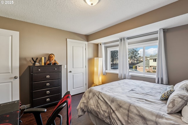 bedroom with dark wood-type flooring and a textured ceiling