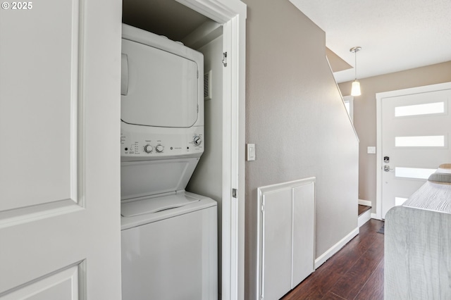 clothes washing area with dark wood-type flooring and stacked washing maching and dryer