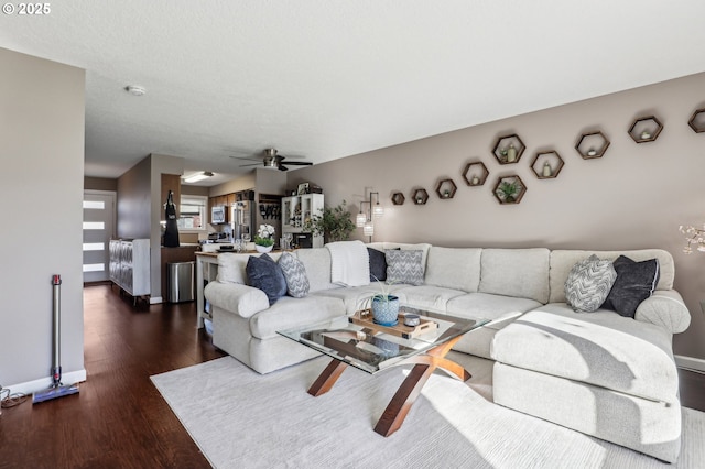 living room featuring ceiling fan and dark hardwood / wood-style flooring