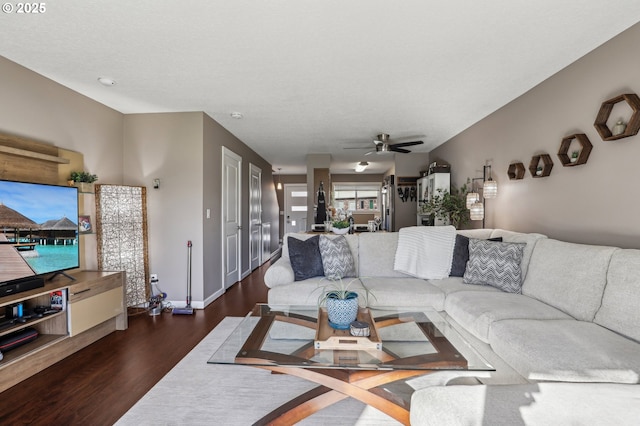 living room featuring ceiling fan and dark hardwood / wood-style flooring