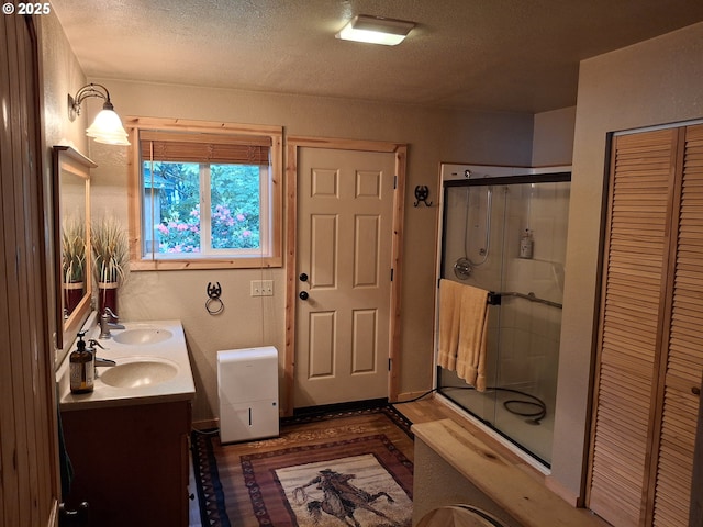 747 N Tenmile, Lakeside, OR 97449 - bathroom featuring double vanity, a stall shower, a closet, and a textured ceiling