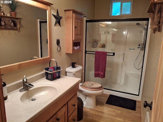 747 N Tenmile, Lakeside, OR 97449 - bathroom with wood finished floors, a textured wall, a stall shower, and vanity