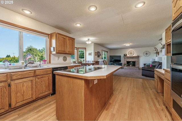 30174 SE Waybill Rd, Boring, OR 97009 - kitchen with a sink, black appliances, a kitchen island, a textured ceiling, and a fireplace