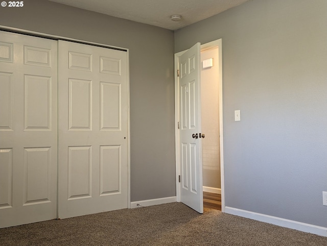 unfurnished bedroom with a closet, carpet, and a textured ceiling