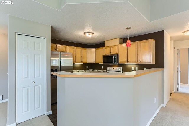 14700 SW Sandhill Loop Unit 204, Beaverton, OR 97007 - kitchen with appliances with stainless steel finishes, a peninsula, light brown cabinetry, light countertops, and a textured ceiling