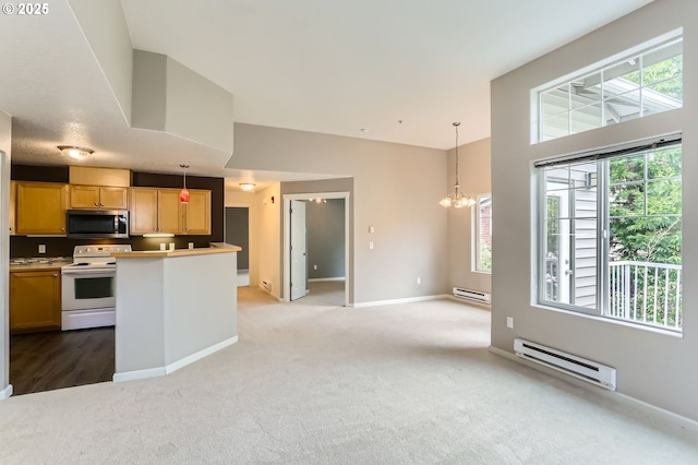14700 SW Sandhill Loop Unit 204, Beaverton, OR 97007 - kitchen featuring white electric range, stainless steel microwave, a baseboard radiator, and plenty of natural light