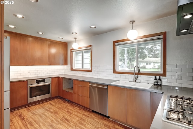 14075 SW Cherryhill Dr, Beaverton, OR 97008 - kitchen with light wood-type flooring, decorative backsplash, stainless steel appliances, and a sink