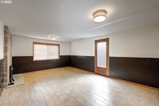 14075 SW Cherryhill Dr, Beaverton, OR 97008 - empty room with wainscoting, wooden walls, a fireplace, and wood finished floors