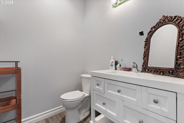 227 Hauser Ct, Molalla, OR 97038 - half bathroom featuring vanity, wood finished floors, toilet, and baseboards