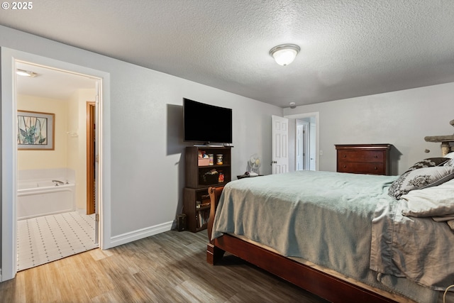227 Hauser Ct, Molalla, OR 97038 - bedroom featuring wood finished floors, a textured ceiling, baseboards, and ensuite bath