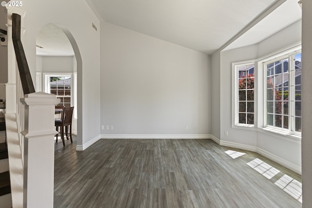 227 Hauser Ct, Molalla, OR 97038 - spare room featuring vaulted ceiling, dark wood-style floors, baseboards, and arched walkways