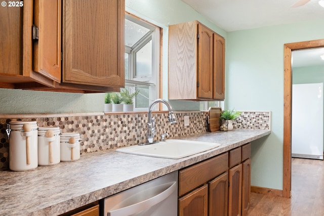 11754 Colvin Rd, Clatskanie, OR 97016 - kitchen with dishwasher, a sink, light wood-style flooring, light countertops, and tasteful backsplash