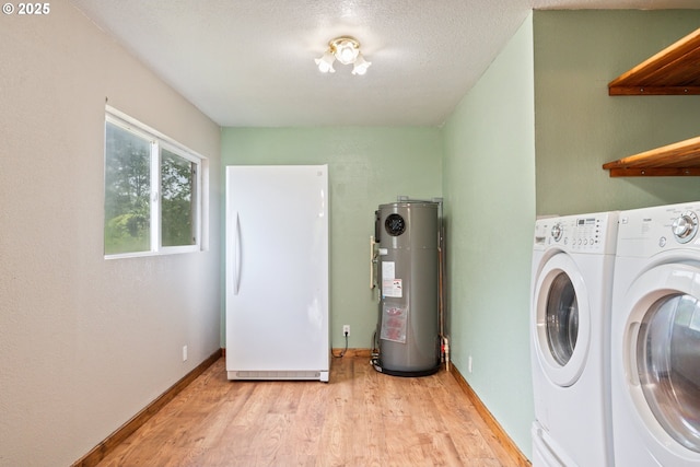 11754 Colvin Rd, Clatskanie, OR 97016 - laundry area with water heater, washing machine and dryer, light wood-style floors, and baseboards