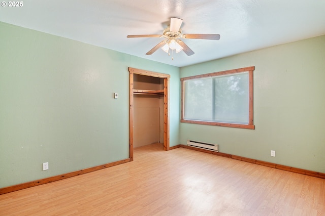 11754 Colvin Rd, Clatskanie, OR 97016 - unfurnished bedroom with baseboard heating, wood finished floors, baseboards, a closet, and a ceiling fan