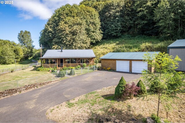 11754 Colvin Rd, Clatskanie, OR 97016 - view of front of house featuring an outdoor structure, a garage, a porch, and metal roof