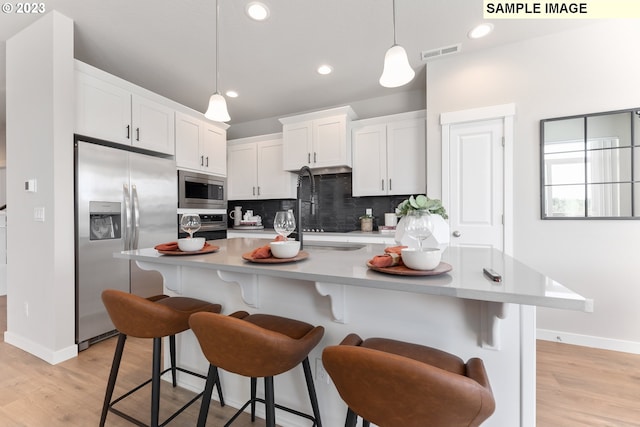 8518 NE 134th Ave Lot 89, Vancouver, WA 98682 - kitchen with appliances with stainless steel finishes, tasteful backsplash, light countertops, white cabinets, and light wood-style floors