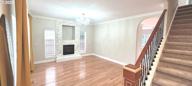 2659 SW Latourell Pl SW, Troutdale, OR 97060 - unfurnished living room with stairs, a chandelier, light wood finished floors, arched walkways, and crown molding