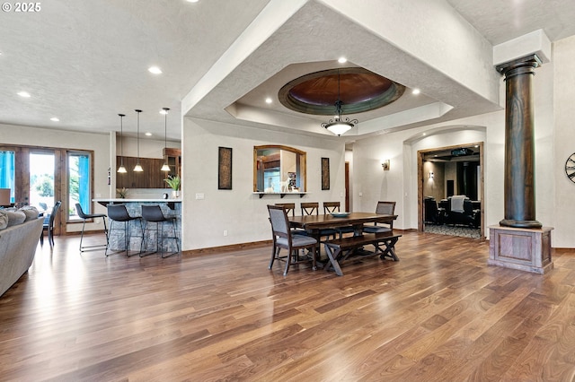 1025 Echo Dr, Roseburg, OR 97470 - dining area featuring wood finished floors, decorative columns, arched walkways, recessed lighting, and a raised ceiling