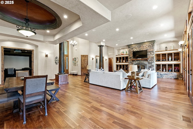 1025 Echo Dr, Roseburg, OR 97470 - living room featuring decorative columns, wood finished floors, built in shelves, a fireplace, and recessed lighting