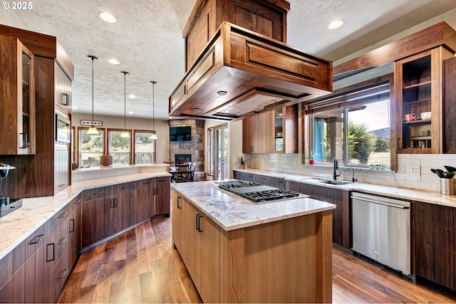 1025 Echo Dr, Roseburg, OR 97470 - kitchen featuring appliances with stainless steel finishes, a textured ceiling, tasteful backsplash, light wood-style flooring, and a kitchen island