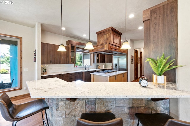 1025 Echo Dr, Roseburg, OR 97470 - kitchen with stainless steel appliances, light stone counters, a kitchen breakfast bar, a center island, and decorative backsplash