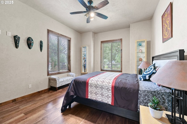 1025 Echo Dr, Roseburg, OR 97470 - bedroom featuring wood finished floors, a ceiling fan, and a fireplace