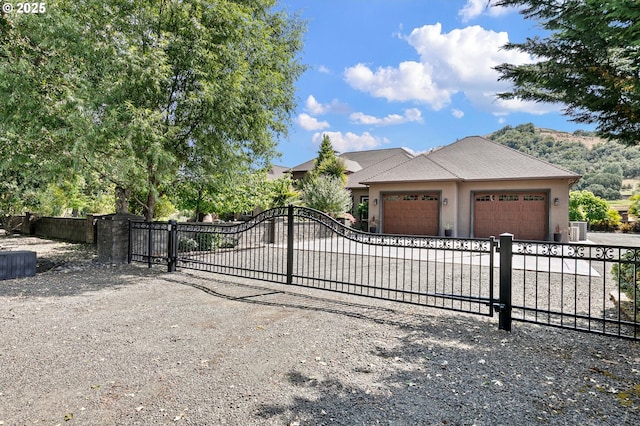 1025 Echo Dr, Roseburg, OR 97470 - view of front of house with a garage, stucco siding, a gate, and driveway