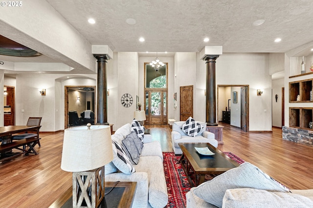 1025 Echo Dr, Roseburg, OR 97470 - living area with decorative columns, light wood-style flooring, a chandelier, a textured ceiling, and recessed lighting