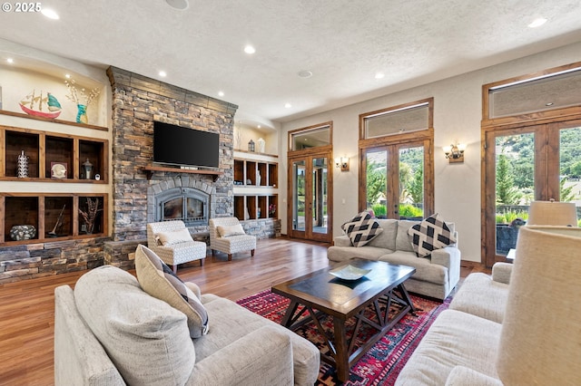 1025 Echo Dr, Roseburg, OR 97470 - living area featuring french doors, a textured ceiling, recessed lighting, wood finished floors, and a fireplace