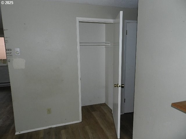 unfurnished bedroom featuring a closet and dark hardwood / wood-style flooring