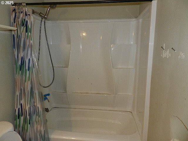 bathroom featuring toilet and shower / tub combo