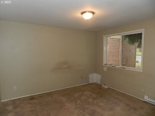 unfurnished room with a baseboard radiator