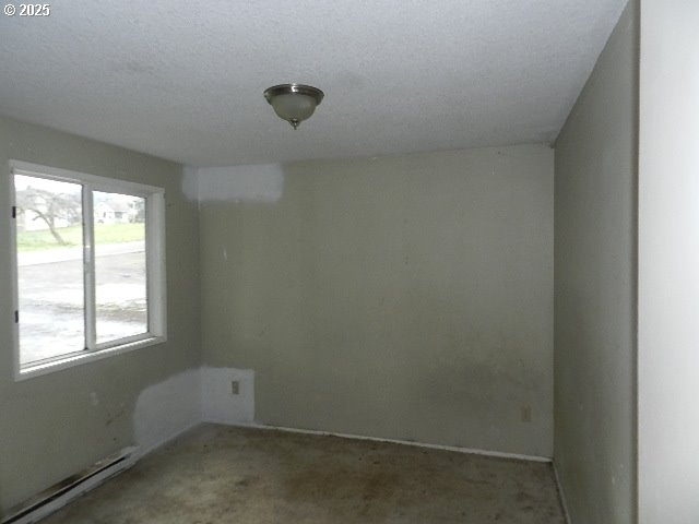 unfurnished room featuring a baseboard heating unit