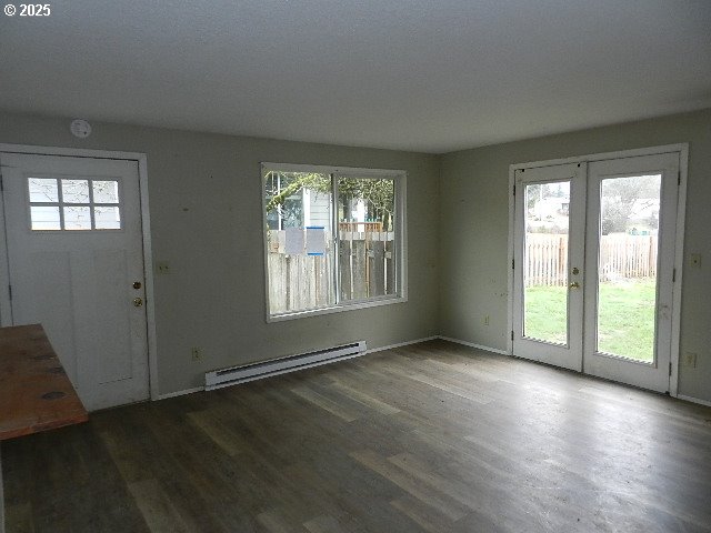 entryway featuring a healthy amount of sunlight, baseboard heating, dark hardwood / wood-style flooring, and french doors