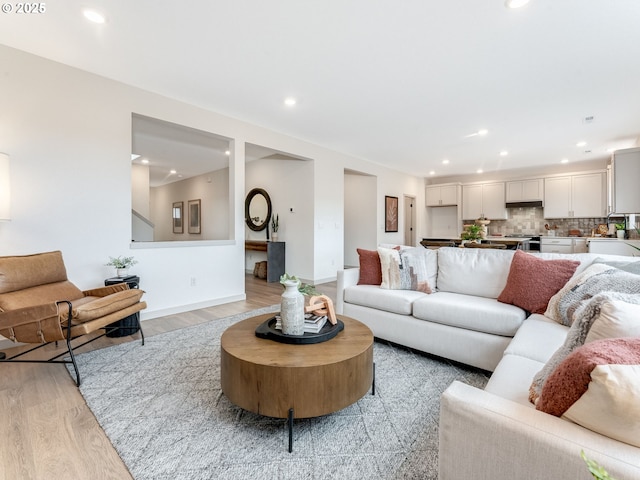 living room featuring light wood-style flooring, baseboards, and recessed lighting