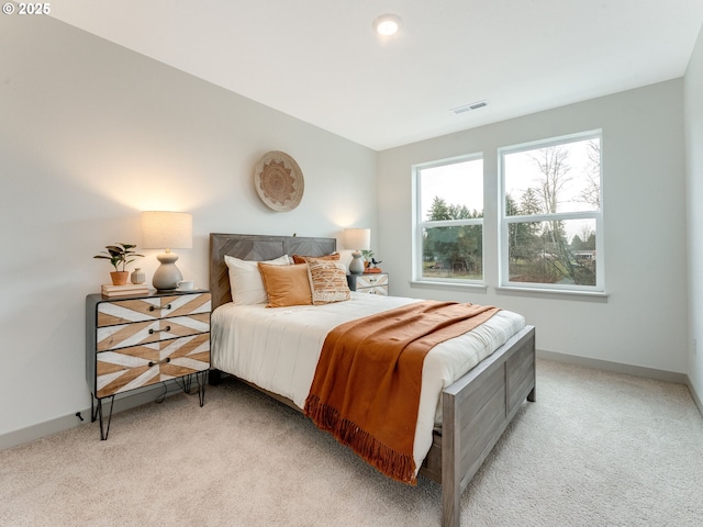 bedroom featuring light colored carpet, visible vents, and baseboards