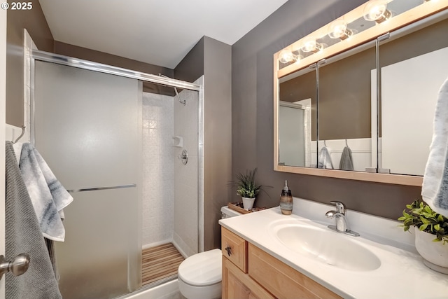 bathroom featuring vanity, an enclosed shower, and toilet