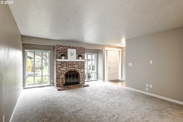 unfurnished living room with a brick fireplace, a textured ceiling, and carpet flooring