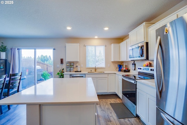 2804 N 3rd Way, Ridgefield, WA 98642 - kitchen with appliances with stainless steel finishes, recessed lighting, light countertops, a sink, and a center island