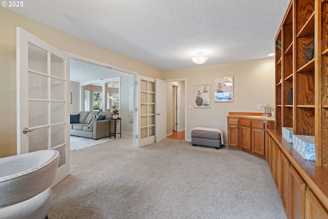 14230 Amberwood Cir, Lake Oswego, OR 97035 - living area with french doors, light carpet, a textured ceiling, and baseboards