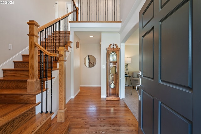 14230 Amberwood Cir, Lake Oswego, OR 97035 - foyer with baseboards, a towering ceiling, wood finished floors, stairs, and arched walkways