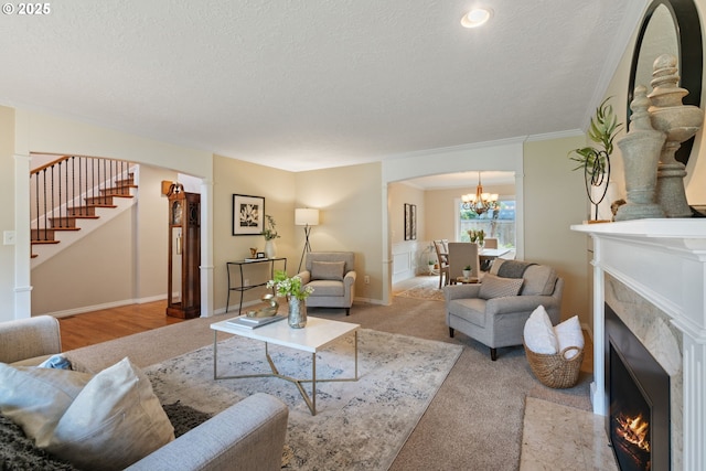 14230 Amberwood Cir, Lake Oswego, OR 97035 - living area featuring a chandelier, a fireplace with flush hearth, stairs, arched walkways, and a textured ceiling