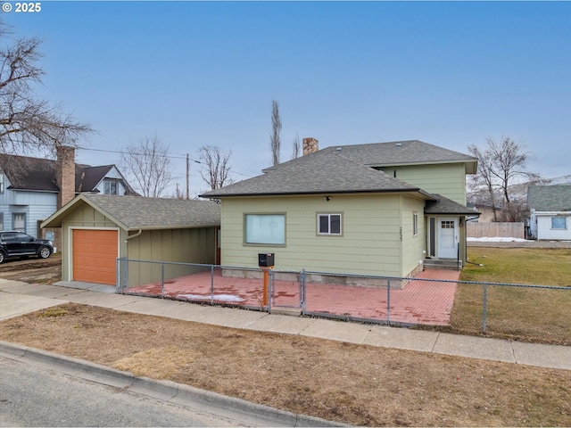 view of front of house featuring a garage, a fenced front yard, a chimney, and roof with shingles