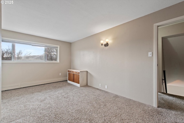 carpeted spare room featuring a baseboard radiator